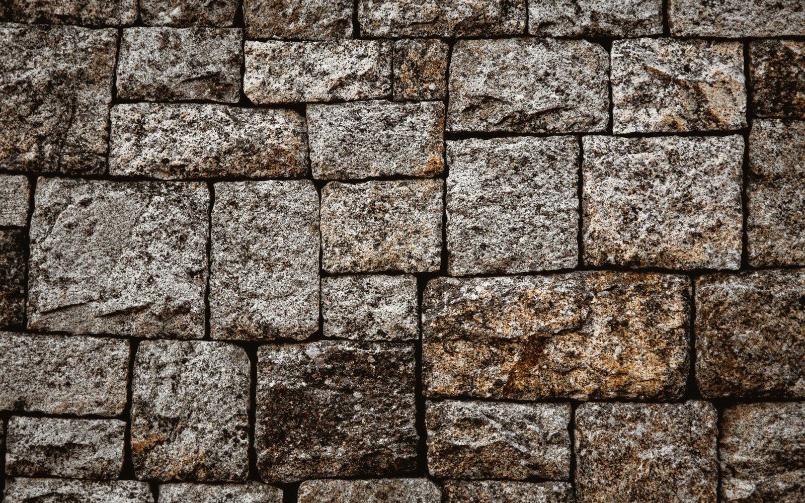 Dry-laid granite coursing close, raking light across the joints