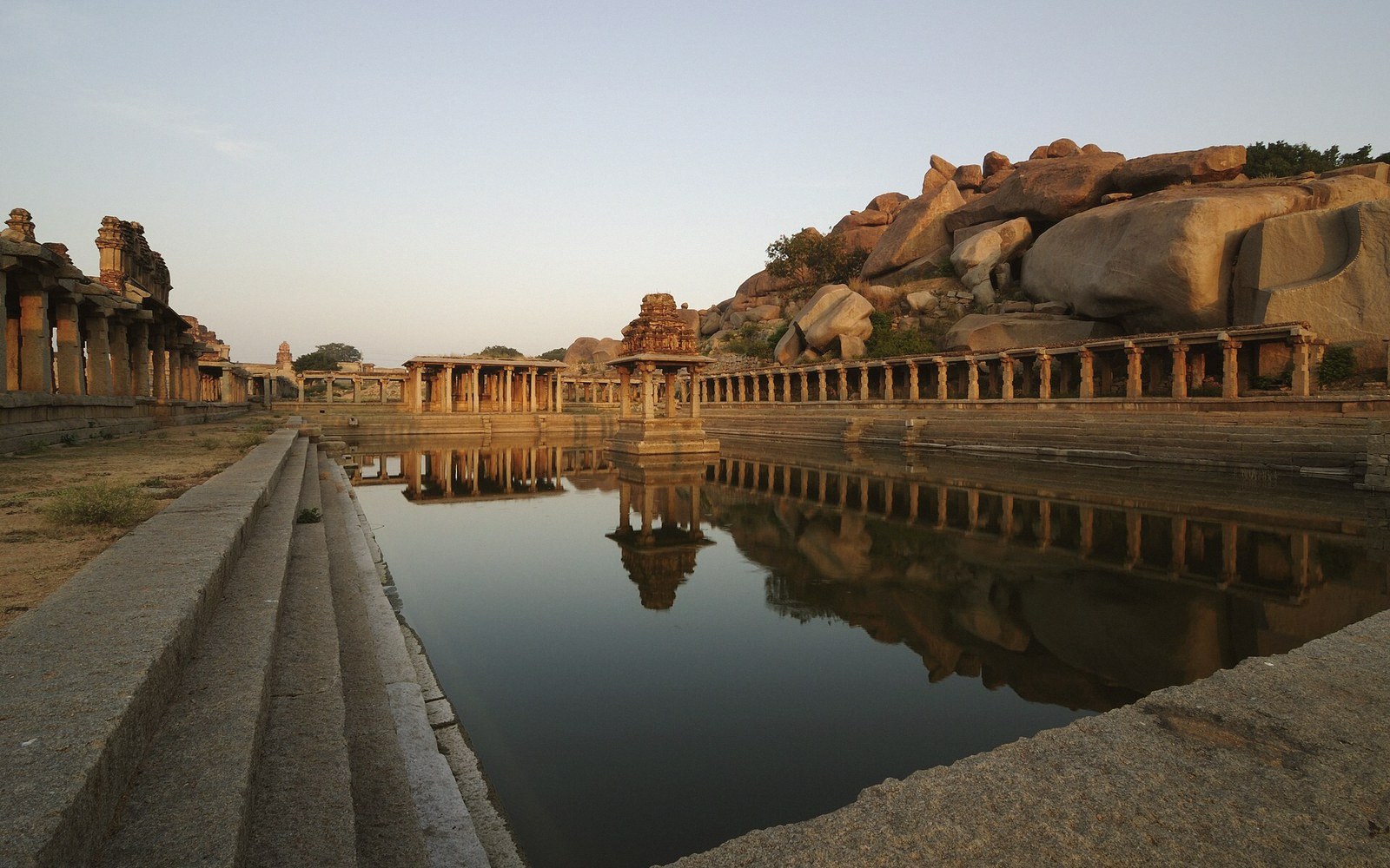 A temple tank with stepped sides down to low water